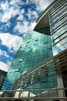 mirror-walled business center with erflection of cloudy sky