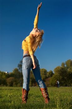 slim shaped beautiful blond girl posing in the park area