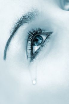 crying woman's eye. tinted monochrome image, high key, selective focus