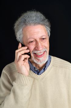 mature man talking on his mobile phone isolated on black background