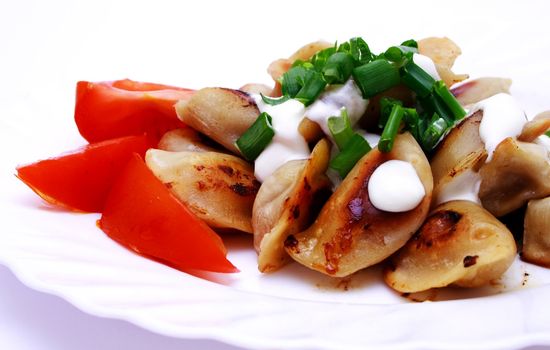 Zoomed foto of dumplings and tomato on plate