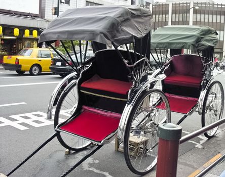 Two Rickshaw parked in urban traffic, Japan