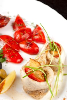 fillet of pikeperch stuffed with trout fish with baked pepper, tomato and leek