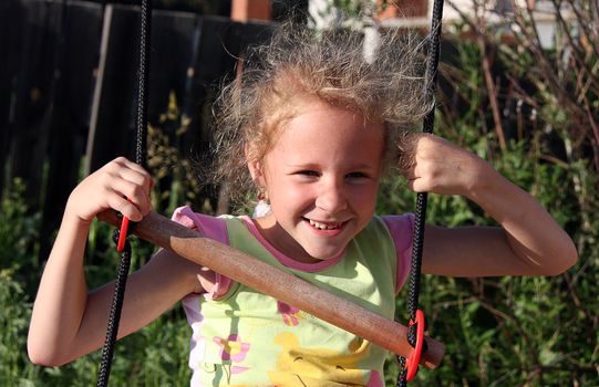 funny girl swinging on a swing