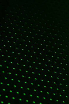 Black plastic mesh texture backlit with green light.