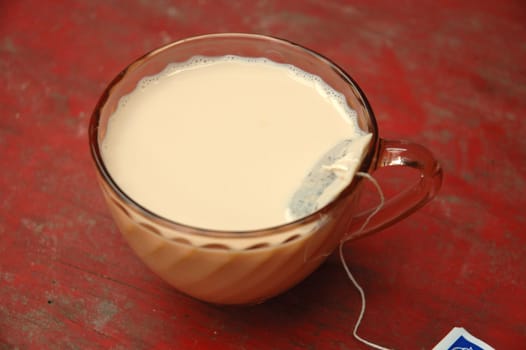 hot tea with milk on porcelain glass
