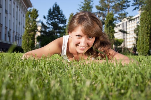A very beautiful young woman lying down smiling in a field