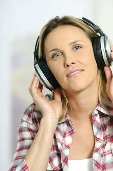blond woman relaxing at home, listening music
