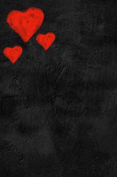 Three red hearts on black background