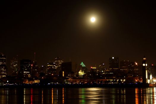 Water edge of Montreal skyline early winter morning with a full moon