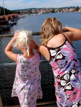 two girls looking over the sea. Please note: No negative use allowed.