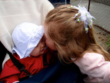little girl kissing the baby