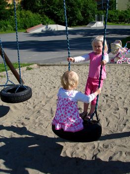 girls playing swing. Please note: No negative use allowed.