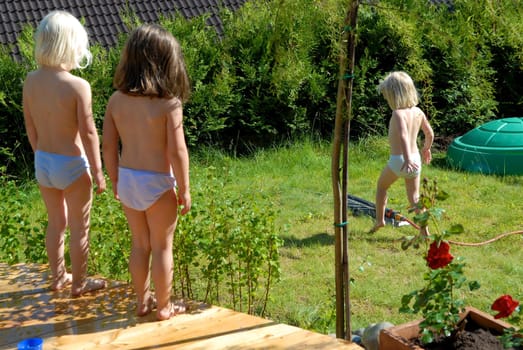 girls playing water in the garden. Please note: No negative use allowed.