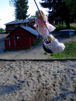 girls playing swing. Please note: No negative use allowed.