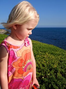 girl picking flowers at the seaside. Please note: No negative use allowed.