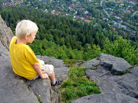 boy sitting on the rock. Please note: No negative use allowed.
