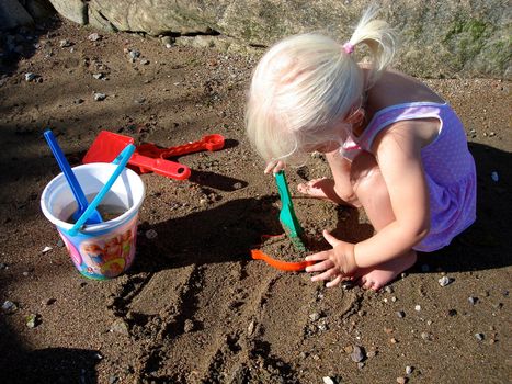 girl playing sand on beach. Please note: No negative use allowed.