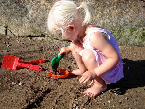 girl playing sand on beach. Please note: No negative use allowed.