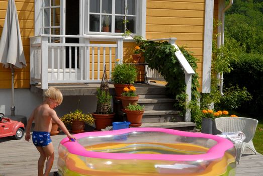 boy playing with the plastic pool. Please note: No negative use allowed.