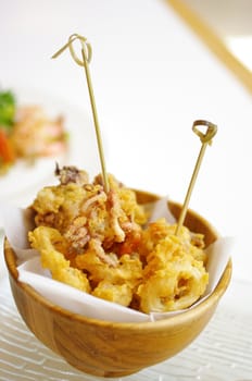 Fried squid with flour in wooden bowl