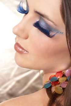 Portrait of a beautiful young brunette woman with dramatic glamour make-up and fashionable earrings