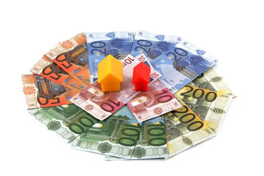 Plastic toy houses on money, isolated on white