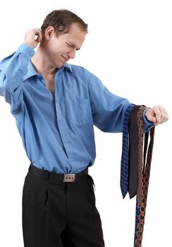 Young successful businessman wearing an office clothes having a problem choosing a tie. Isolated on white background