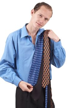 Young successful businessman wearing office clothes choosing a tie. Isolated on white background