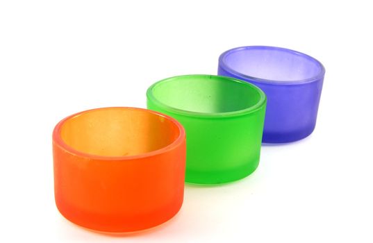 Colored candle holders on white background 