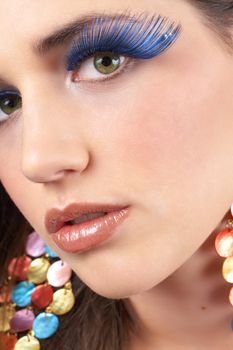 Portrait of a beautiful young brunette woman with dramatic glamour make-up and fashionable earrings