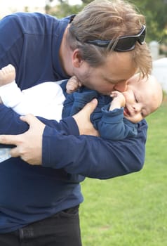 Young father kissing his small son. Focus is on the father