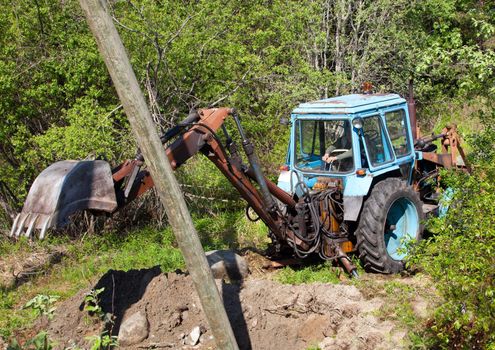 Excavation for installation of the column on the background of green forest