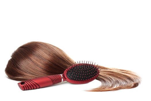 Long and brown female hair with red brush. Isolated over white background