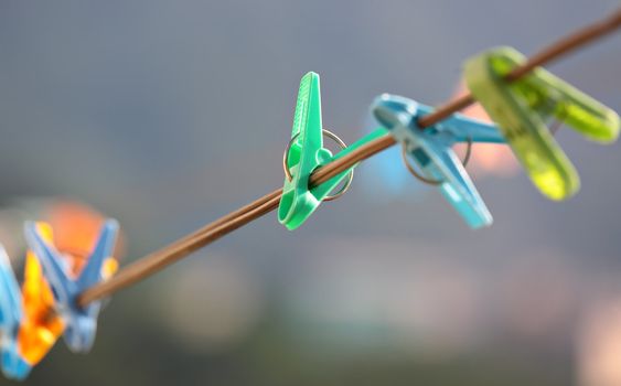 Colorful clothes pegs hanging in wire