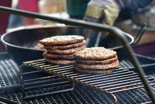 A bunch of newly grilled hamburgers.