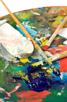 artist's palette with colorful paint and brushes.