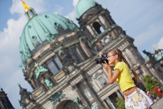 young girl with photo camera on Cathedral in Berlin background