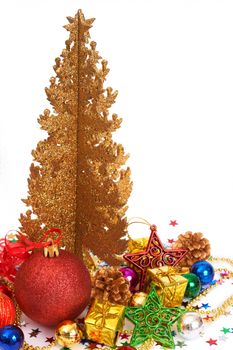 Colorful Christmas baubles and decorations next to golden tree isolated on white background with copy space. 