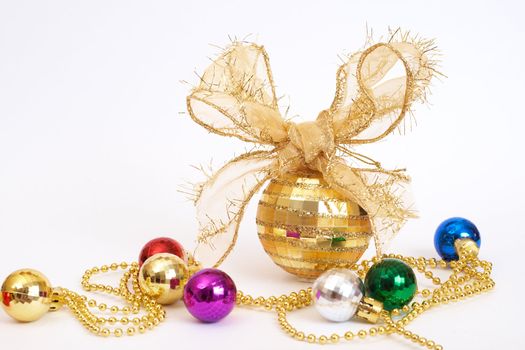 Gold Christmas bauble with colorful small balls on white background with copy space. 