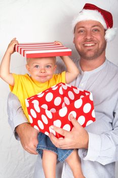 Baby boy with his father for Christmas holding a large gift box