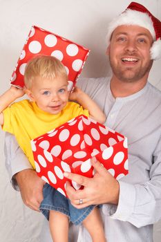 Baby boy with his father for Christmas holding a large gift box