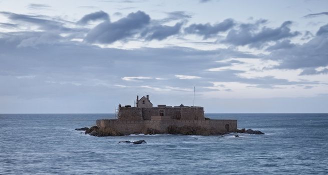 Dusk image of The Fort National from Saint Malo,in Brittany in northwestern France, during the high tide time.The construction was used first as a reference point for the ships and from 1869 became a defensive bastion against the English attacks.