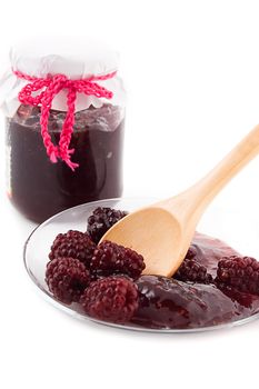 Blackberry jam in bowl and in plate on wooden spoon