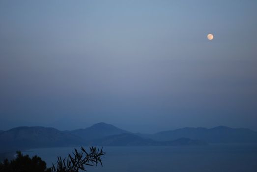 Night Landscape with Moon, Sea and Misty Mountains Far Away