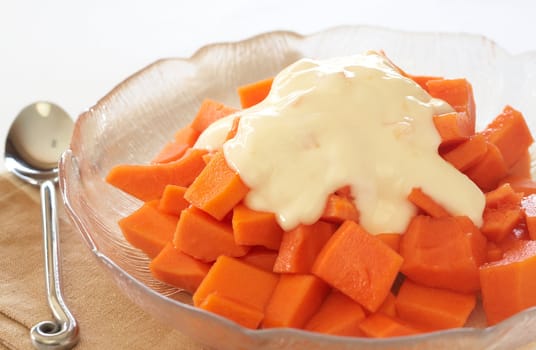 Bowl of summer papaya fruit salad with topping of fresh yoghurt