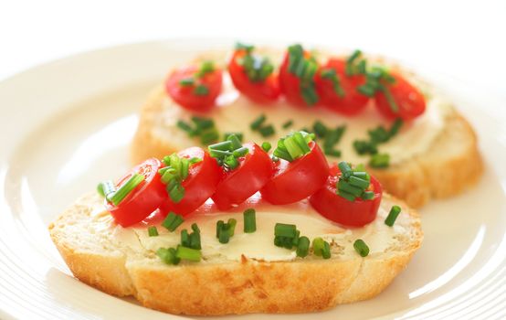 Tasty sandwich with cream cheese, baby tomatoes and spring onions on white loaf bread