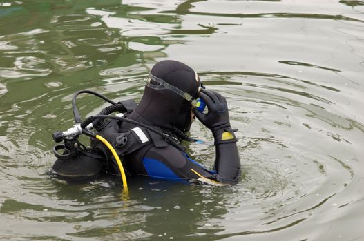 Scuba diver in wet suit entering the cold water