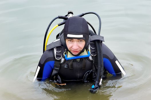 Scuba diver in wet suit entering the cold water