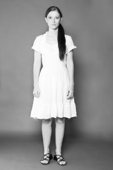 Studio portrait of a classic simple girl in a white dress